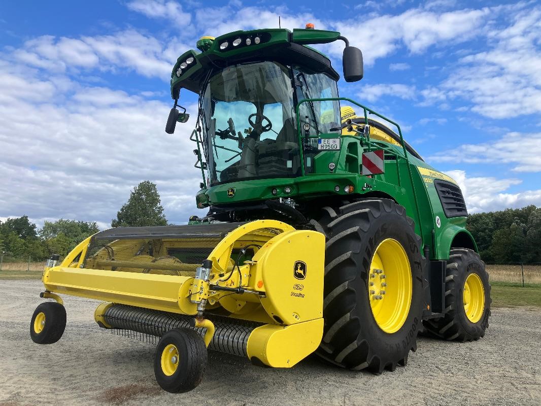 A 2023 John Deere 9500 self-propelled forage harvester sits near a field.
