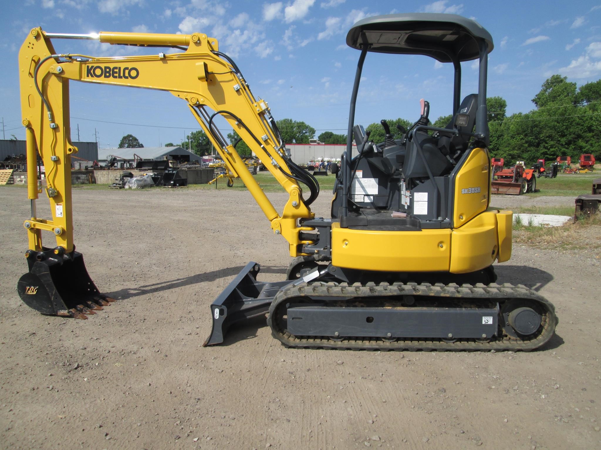 A 2024 Kobelco SK35SR-7 mini excavator sits on a lot.