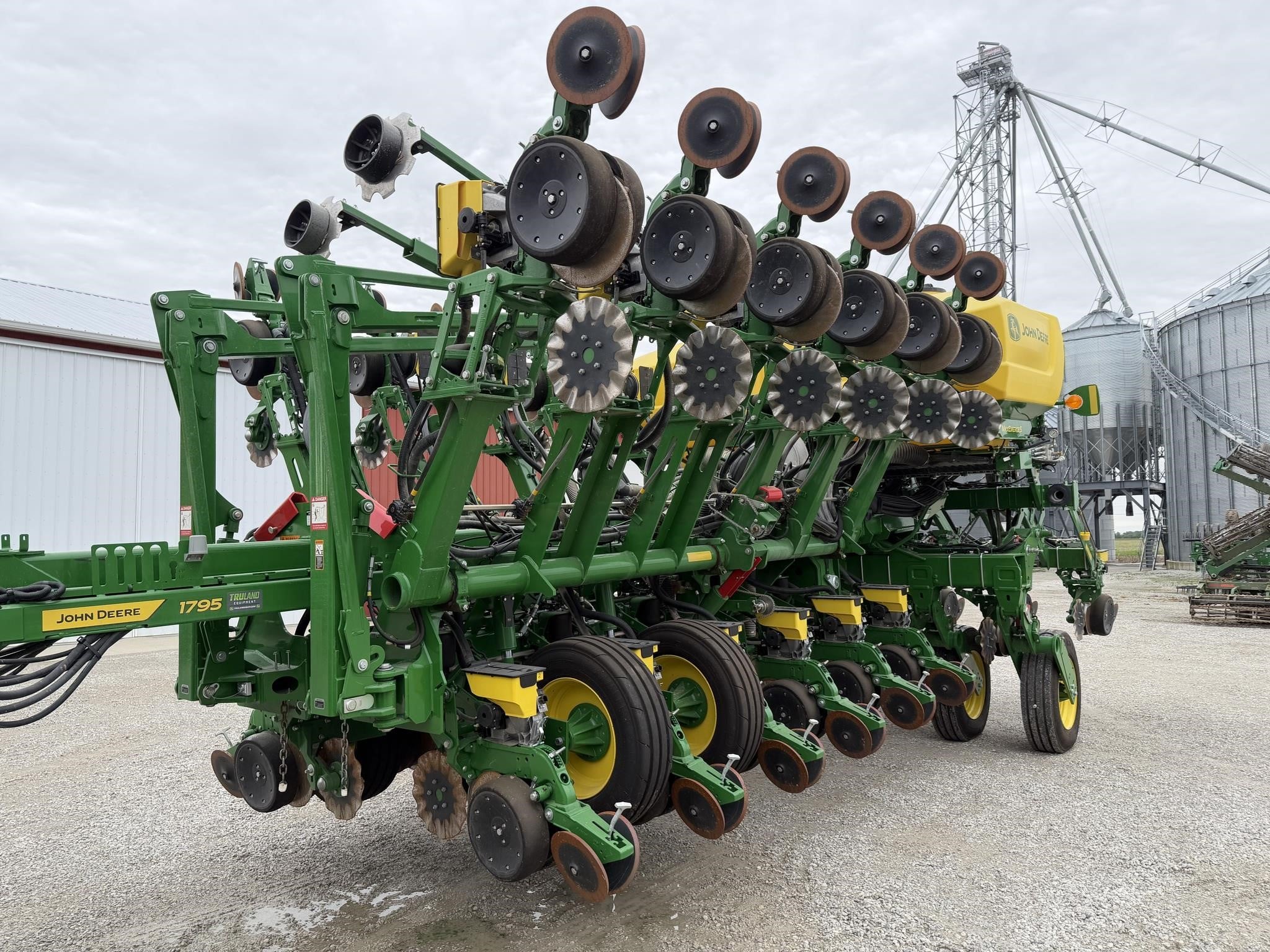 Green 2024 John Deere 1795 planter parked on a farm outdoors.