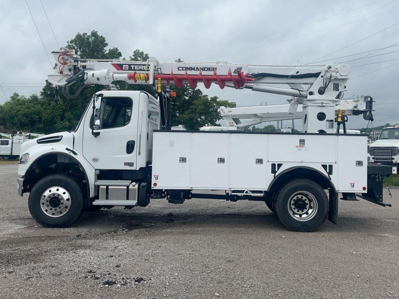 2026 Terex Commander 4047 truck-mounted hole borer parked outdoors surrounded by trees.