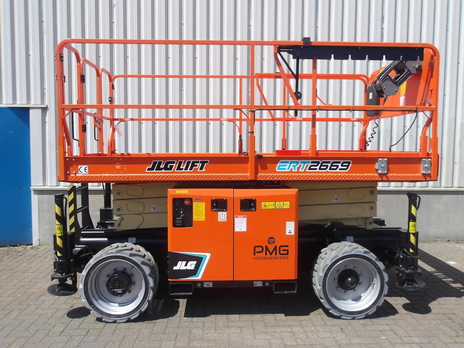 Orange 2022 JLG ERT2669 rough-terrain scissor lift parked outdoors with a white shed in the background.