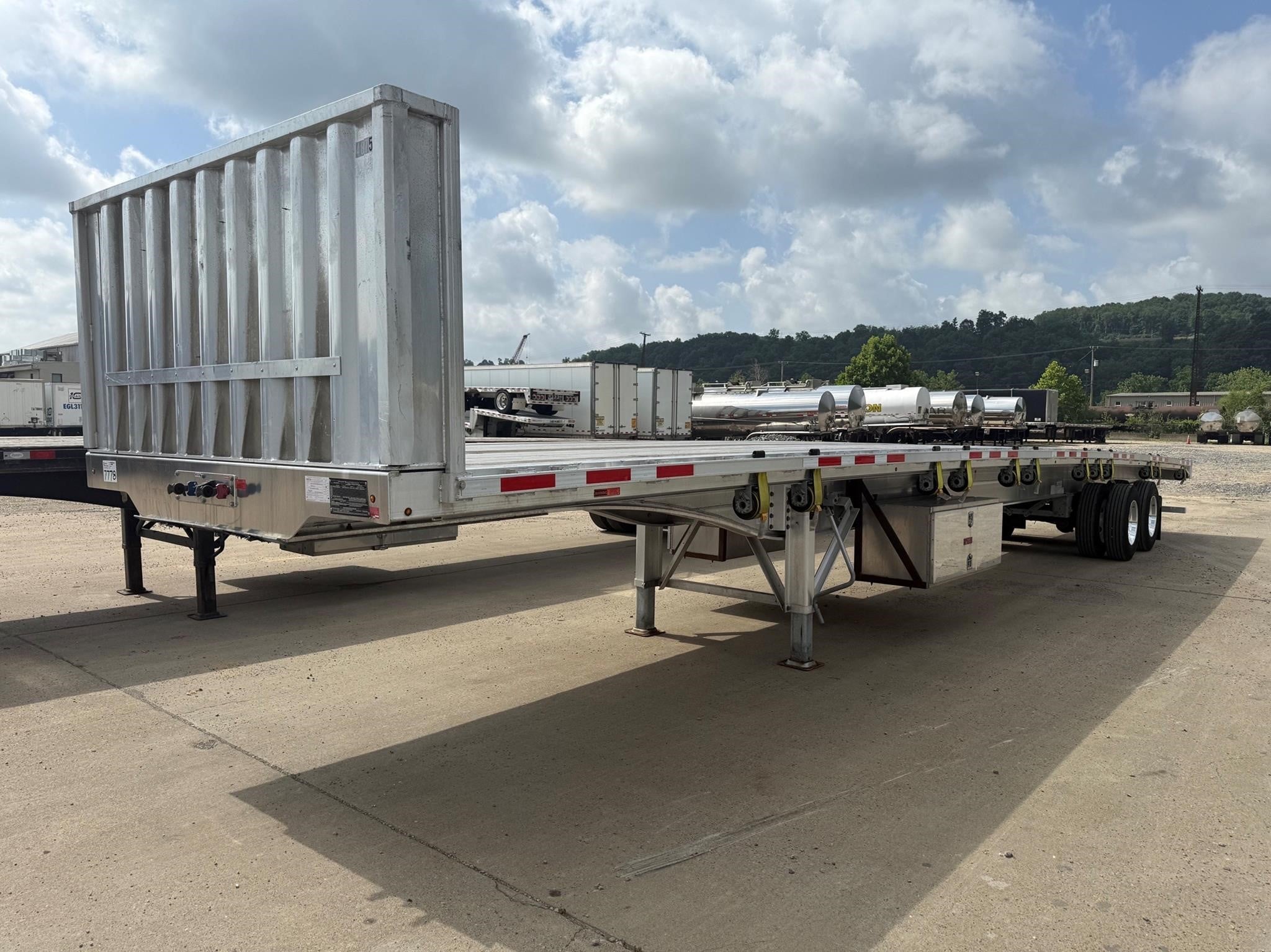 2023 Benson flat-top trailer parked on cement outdoors.