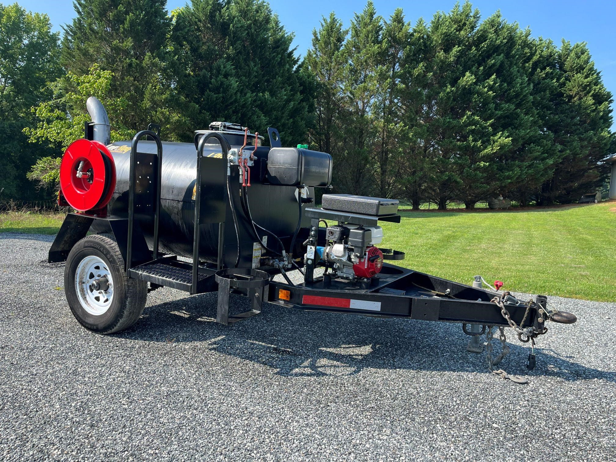 A 2023 Leeboy L300 towable asphalt distributor parked outdoors.