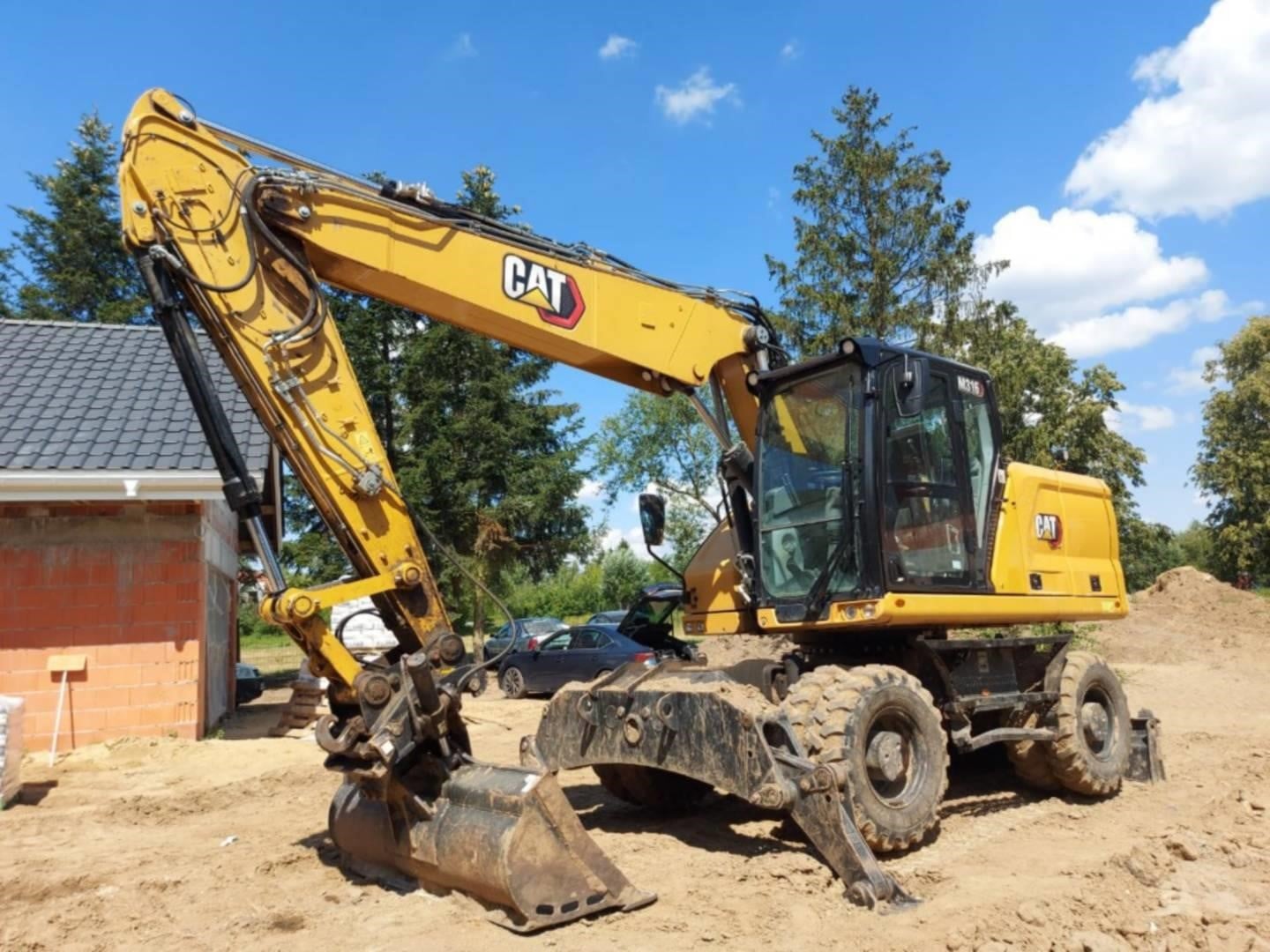 2021 Caterpillar M316 wheeled excavator parked outdoors.