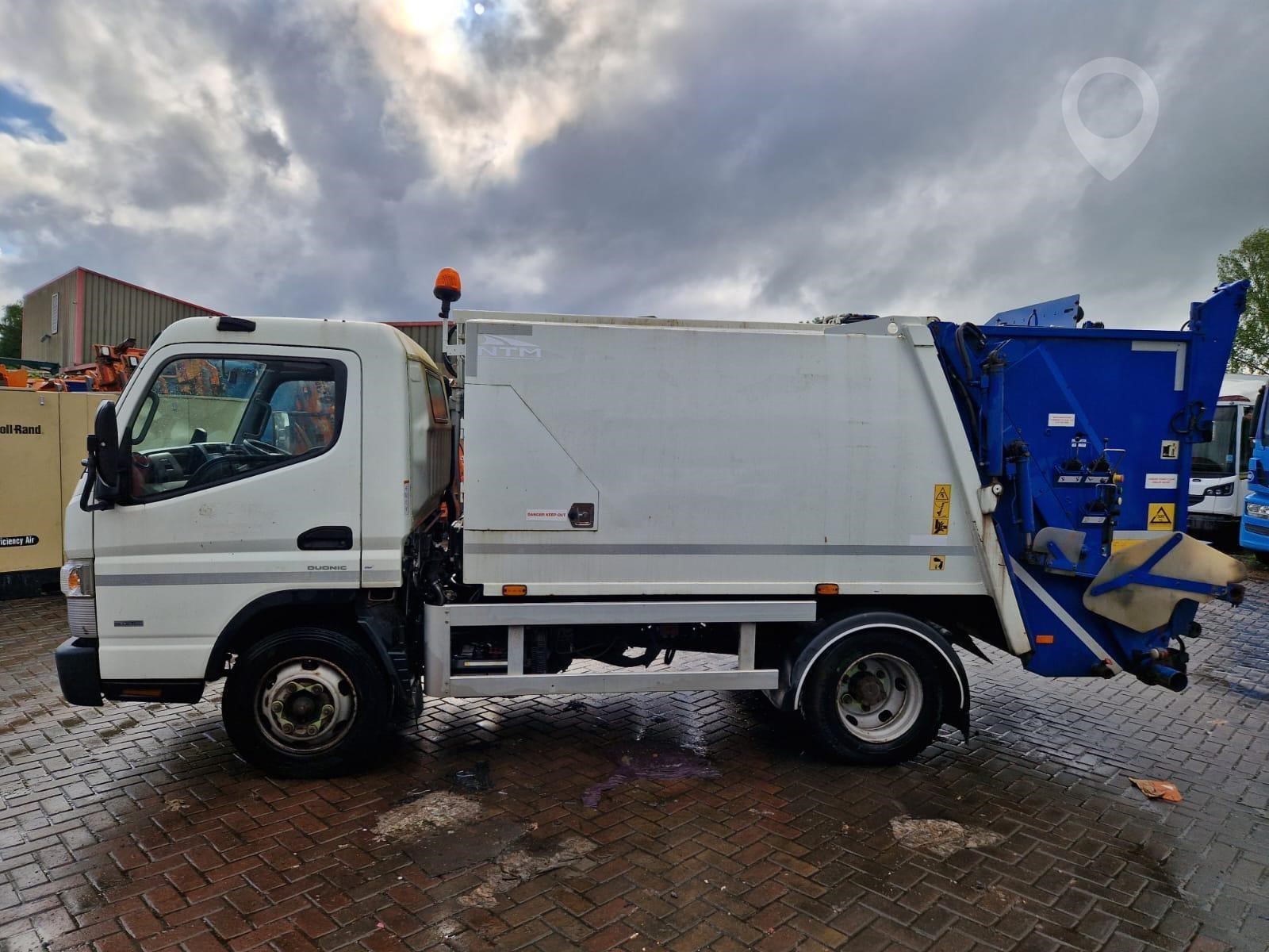 A 2017 Mitsubishi Fuso Canter 75 refuse/recycling van sits on a lot.