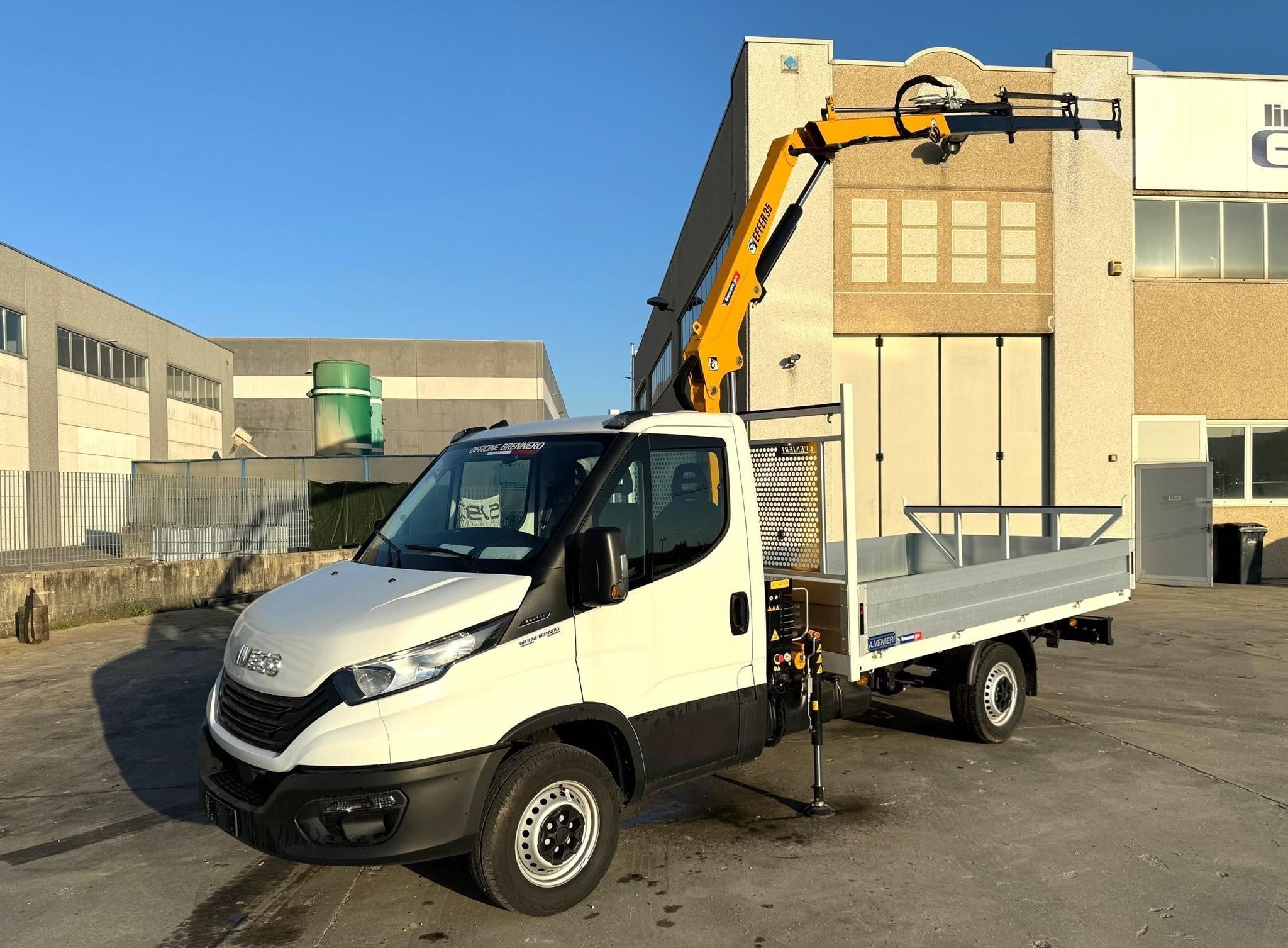 A 2025 Iveco Daily 35S14 dropside crane van sits on a lot.