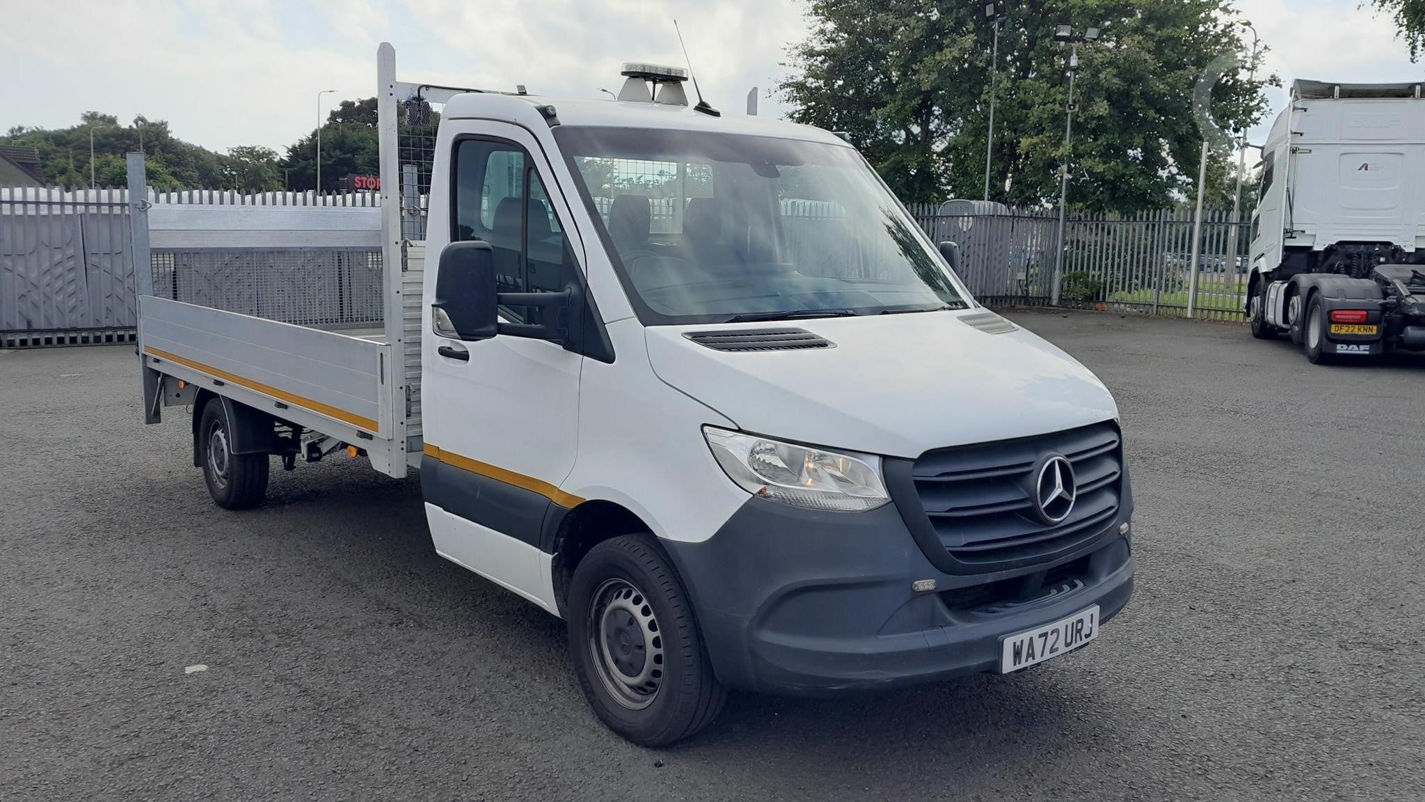 A 2022 Mercedes-Benz Sprinter 315 dropside flatbed van sits on a lot.