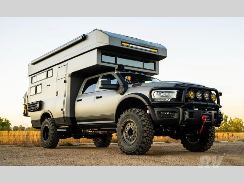 A 2026 Rossmonster Baja Plus truck camper parked on a dirt road.