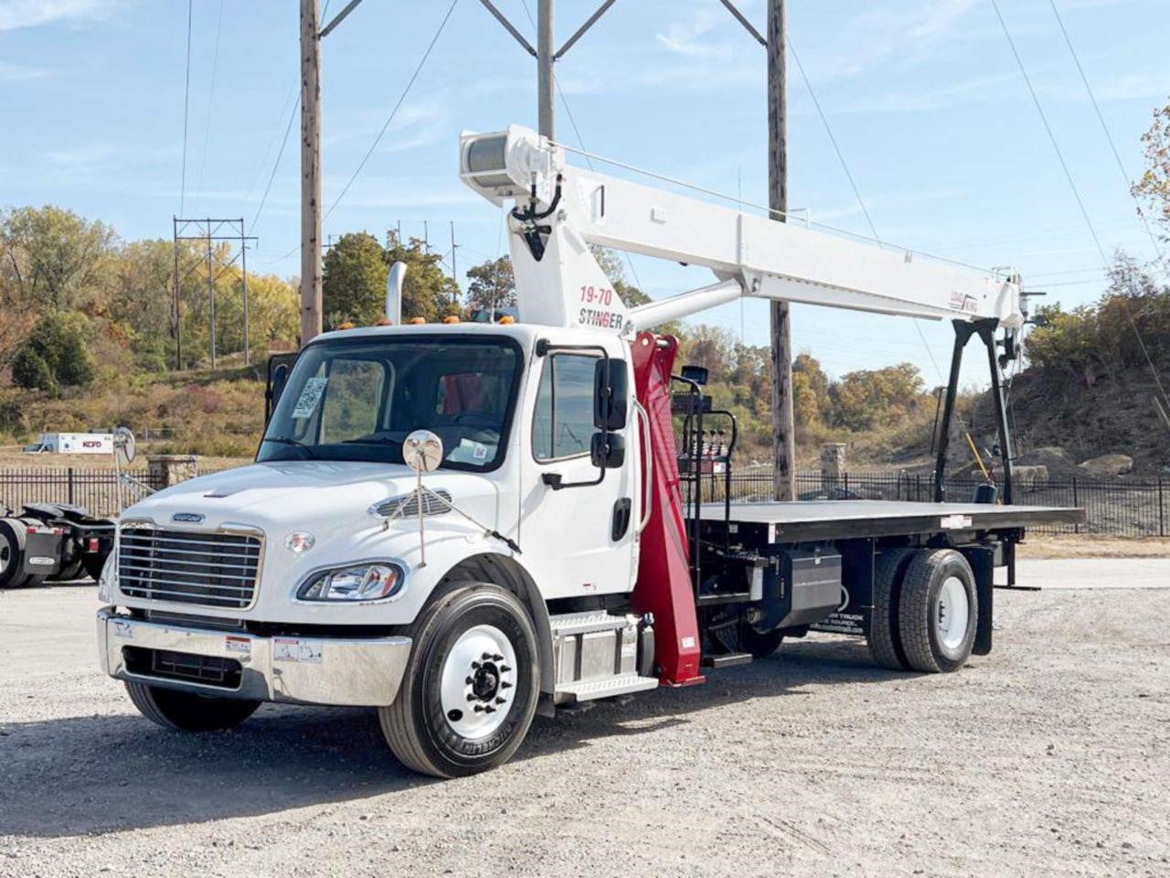 A 2026 Load King Stinger 19-70 mounted boom truck crane parked outdoors.