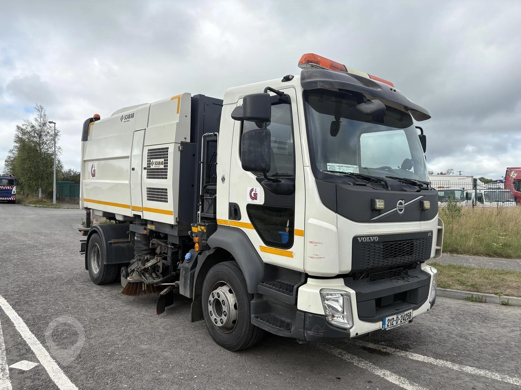 A 2021 Volvo FL250 road sweeper on a street.