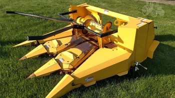 A 2013 New Holland 3PN row crop forage header outdoors on grass.
