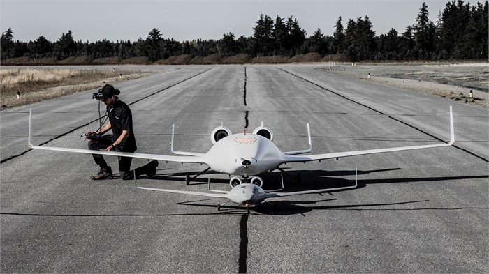 A researcher inspects test vehicles from Bombardier’s EcoJet Research Project with 18- and 8-foot wingspans on a runway.