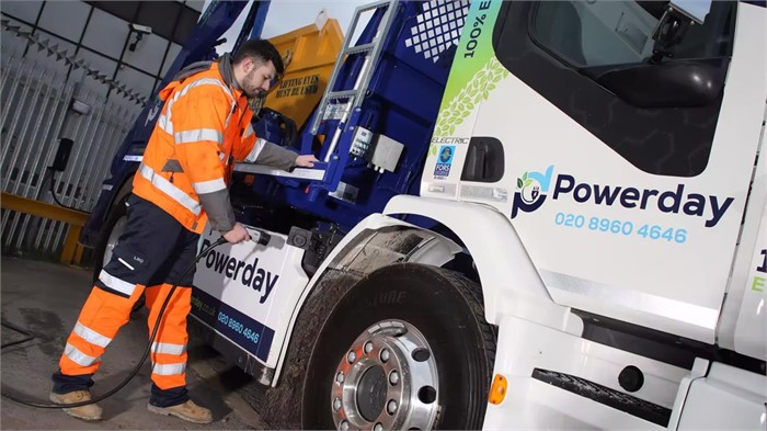 A Powerday worker plugging in one of the firm’s new Volvo FE Electric skip loaders to recharge it.