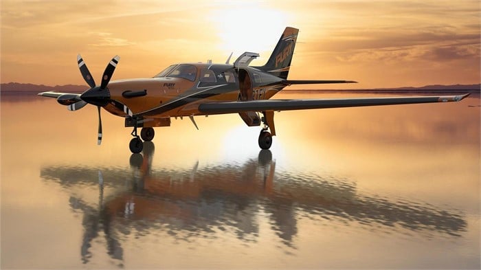 A Piper M700 Fury single-engine turboprop airplane flies over a body of water with city skyscrapers in the background.