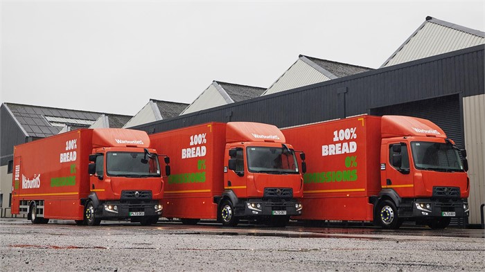 Three Renault E-Tech D16 box-bodied trucks sit in front of a depot.