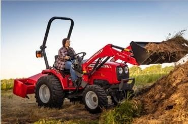 a person driving a red tractor with dirt loaded in the front bucket