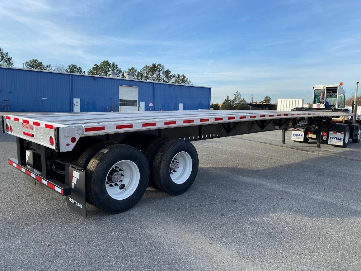 A 2022 Fontaine flatbed semi-trailer sits on a lot.