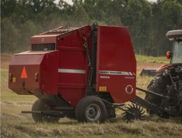 a red baler working in a field